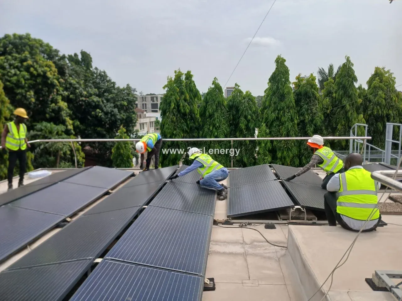 A team of installers positioning solar panels on a flat rooftop.