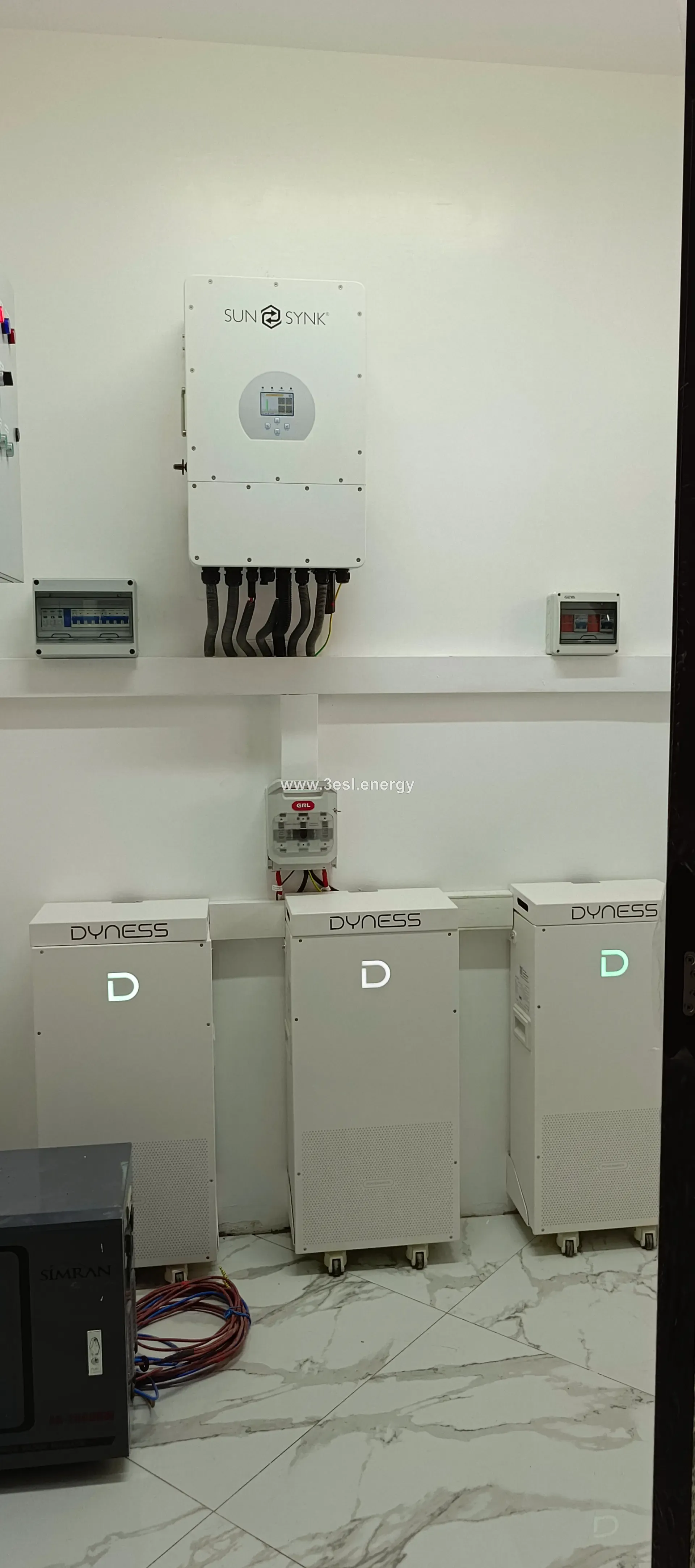 A floor-standing bank of Dyness lithium battery modules wired into a residential system.