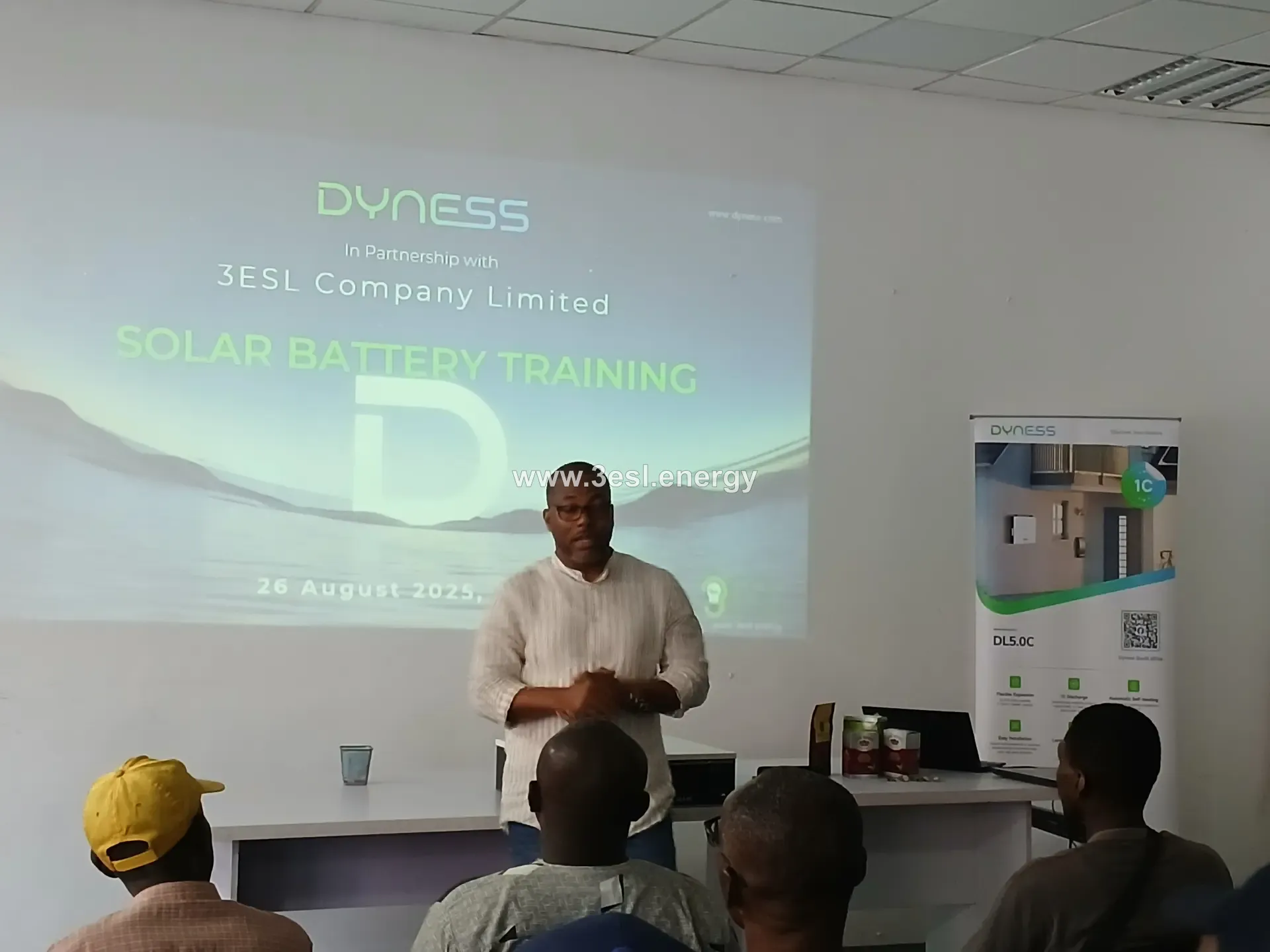 A presenter addressing an audience at a Dyness battery training event.