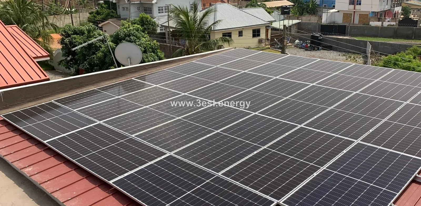 Solar panels covering a red metal residential rooftop.