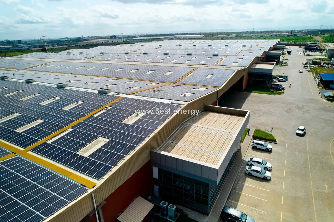 Aerial view of an industrial site whose roofs are almost completely covered in photovoltaic modules.